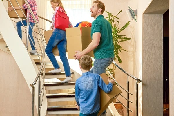 Family carrying boxes upstairs.